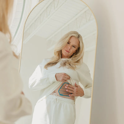Woman applying Signal Relief patch to her abdomen.